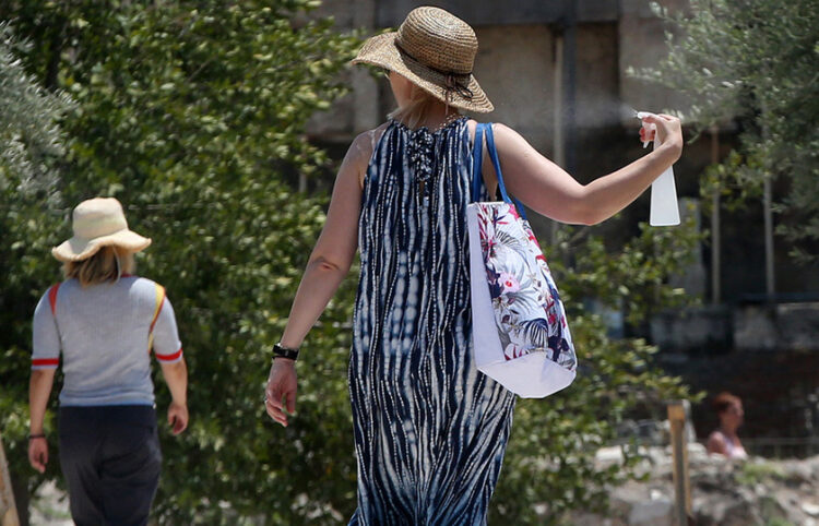 Αθηναίοι και τουρίστες προστατεύονται με όποιo τρόπο μπορούν από τις υψηλές θερμοκρασίες και τον καυτό ήλιο (φωτ.: ΑΠΕ-ΜΠΕ / Ορέστης Παναγιώτου)