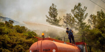 Ρίψη νερού σε μια από τις αναζωπυρώσεις στο Βάτι Ρόδου (φωτ.: EUROKINISSI / Λευτέρης Δαμιανίδης)