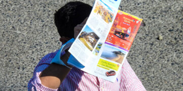 Τουρίστας προστατεύει το κεφάλι του από τη ζέστη με έναν χάρτη της Κέρκυρας (φωτ.: EUROKINISSI / Γιώργος Κονταρίνης)