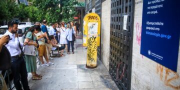 Πολίτες περιμένουν στην ουρά για να εξυπηρετηθούν στο κτηματολογικό γραφείο της Αθήνας, υπό την ανακοίνωση για τις νέες ψηφιακές υπηρεσίες (φωτ.: EUROKINISSI/Γιάννης Παναγόπουλος)
