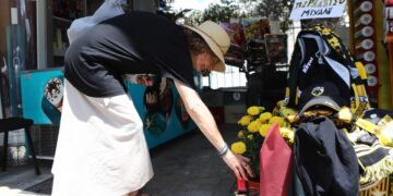 Μια γυναίκα αφήνει αναμνηστικά στον τόπο της δολοφονίας του Μιχάλη Κατσουρή (φωτ.: EUROKINISSI/Στέλιος Στεφάνου)