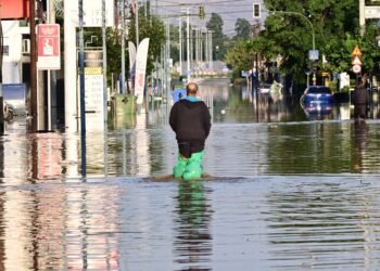Κάτοικος διασχίζει με σακούλες στα πόδια πλημμυρισμένο δρόμο της Λάρισας, Σάββατο 9 Σεπτεμβρίου 2023 (φωτ.:Eurokinissi/Μιχάλης Καραγιάννης)