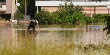Άνδρας περπατάει σε πλημμυρισμένο δρόμο στη συνοικία του Ιπποκράτη στην Λάρισα, κατά τη διάρκεια της κακοκαιρίας Daniel (φωτ.: ΑΠΕ-ΜΠΕ / Αποστόλης Ντόμαλης)