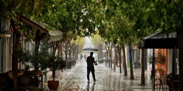 Φθινοπωρινό το σκηνικό στην Κόρινθο, όπου άνδρας κρατώντας ομπρέλα περπατάει σε πεζόδρομο (φωτ.: ΑΠΕ-ΜΠΕ/Βασίλης Ψωμάς)