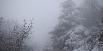Aυτοκίνητο διασχίζει χιονισμένο δασικό δρόμο στο βουνό του Χορτιάτη (φωτ.: ΑΠΕ-ΜΠΕ / Δημήτρης Τοσίδης)
