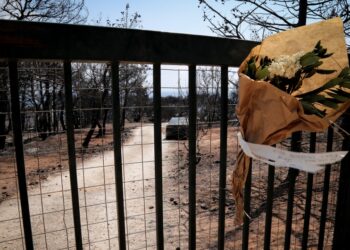 Μια ανθοδέσμη στην αυλόπορτα σπιτιού που κάηκε ολοσχερώς από την πυρκαγιά της 23ης Ιουλίου του 2018 (φωτ.: EUROKINISSI/Βασίλης Ρεμπάπης)