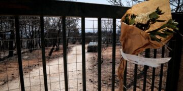 Μια ανθοδέσμη στην αυλόπορτα σπιτιού που κάηκε ολοσχερώς από την πυρκαγιά της 23ης Ιουλίου του 2018 (φωτ.: EUROKINISSI/Βασίλης Ρεμπάπης)