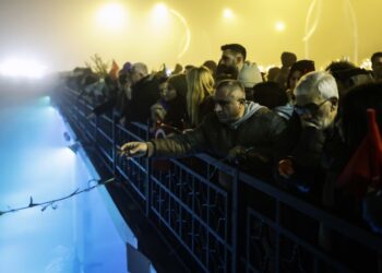 Πολίτες ρίχνουν γαρύφαλλα στον ποταμό Ορόντη, στη διάρκεια της αγρυπνίας στο Χατάι, στη μνήμη των νεκρών του φονικού σεισμού της 6ης Φεβρουαρίου του 2023 (φωτ.: EPA/Erdem Sahin)