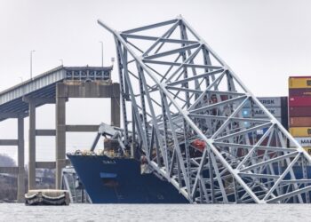 Συντρίμμια από τη γέφυρα φαίνονται δίπλα στην πλώρη του πλοίου το οποίο γκρέμισε τον πυλώνα της, με αποτέλεσμα αυτή να καταρρεύσει, παρασέρνοντας στο θάνατο έξι ανθρώπους (φωτ.: . EPA/Jim Lo Scalzo)