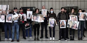 Συγγενείς των θυμάτων κρατούν φωτογραφίες των αγαπημένων τους στη δίκη για την πυρκαγιά στο Μάτι (φωτ.: EUROKINISSI/Κώστας Τζούμας)