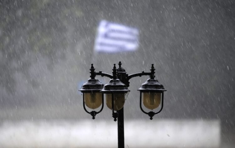 Μια ελληνική σημαία κυματίζει στον δυνατό αέρα κατά την διάρκεια καταιγίδας (φωτ.: Eurokinissi/Θανάσης Καλλιάρας)