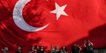 Πολίτες στέκονται μπροστά από μια γιγάντια τουρκική σημαία στη διάρκεια εθνικών εορτασμών στην Κωνσταντινούπολη (φωτ.: EPA / Erdem Sahin)