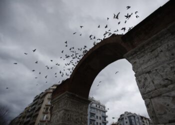 Περιστέρια πετούν γύρω από το μνημείο της Καμάρας σε μια συννεφιασμένη Θεσσαλονίκη (φωτ.: ΑΠΕ-ΜΠΕ / Δημήτρης Τοσίδης)