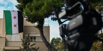 Στιγμιότυπο από την πρεσβεία της Συρίας στο Ψυχικό, νωρίτερα σήμερα. Σύροι, υποστηρικτές των ανταρτών, μπήκαν μέσα στην πρεσβεία και κρέμασαν τη σημαία της επανάστασης στο μπαλκόνι του κτηρίου (φωτ.:  Κώστας Τζούμας/ EUROKINISSI)