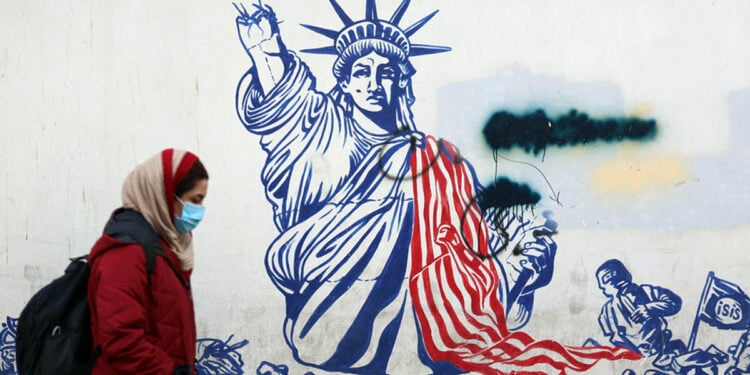 Μια Ιρανή περνά δίπλα από αντι-αμερικανική τοιχογραφία έξω από το πρώην κτήριο της πρεσβείας των ΗΠΑ στην Τεχεράνη, μία ημέρα μετά την ορκωμοσία του Ντόναλντ Τραμπ ως 47ου προέδρου των ΗΠΑ. Τεχεράνη, 21 Ιανουαρίου 2025. (φωτ.: EPA / Abedin Taherkenareh)