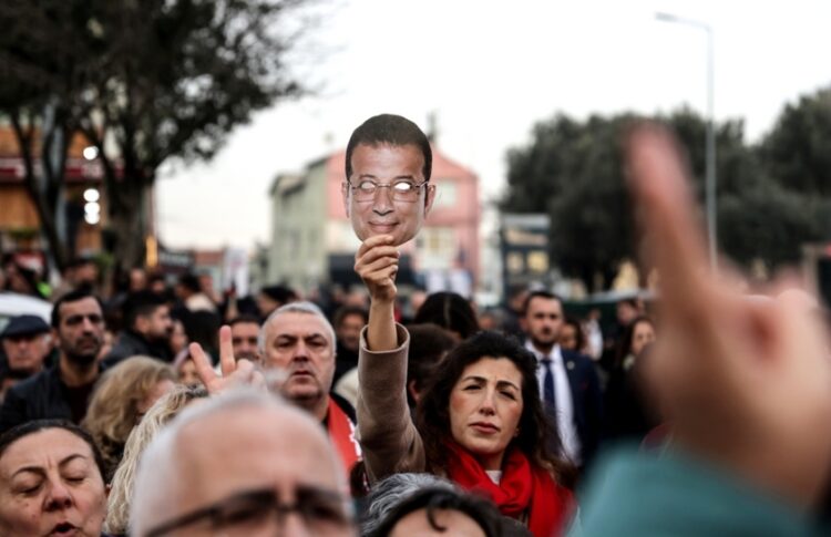 Υποστηρικτές του Εκρέμ Ιμάμογλου κρατούν μάσκες με τη φωτογραφία του στη διάρκεια διαδήλωσης κατά των δικαστικών διώξεων που υφίσταται μπροστά από το δικαστικό μέγαρο της Κωνσταντινούπολης (φωτ.: EPA/Erdem Sahin)