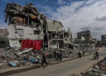 Παλαιστίνιοι περπατούν μπροστά από κατεστραμμένα σπίτια στη Γάζα (φωτ.: EPA / Mohammed Saber)