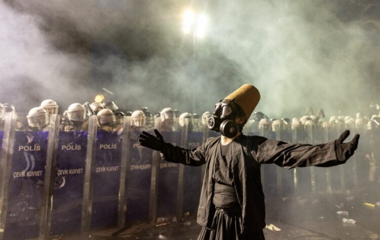 Διαδηλωτής φορά στολή δερβίση και αντιασφυξιογόνα μάσκα μπροστά από αστυνομικό κλοιό στην πλατεία Ταξίμ, στην Κωνσταντινούπολη (φωτ.: EPA/Erdem Sahin)