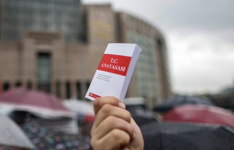 Άνδρας κρατά βιβλίο με το τουρκικό σύνταγμα στη διάρκεια διαμαρτυρίας για το Ανώτατο Δικαστήριο της χώρας έξω από το Δικαστικό Μέγαρο της Κωνσταντινούπολης (φωτ.: EPA/Erdem Sahin)