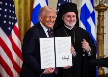 Ο πρόεδρος των ΗΠΑ κρατάει τη διακήρυξη που αναγνωρίζει την 25η Μαρτίου ως Ημέρα της Ελληνικής Ανεξαρτησίας. Δίπλα του ο Αρχιεπίσκοπος Αμερικής Ελπιδοφόρος (φωτ.: EPA/Samuel Corum/ POOL)