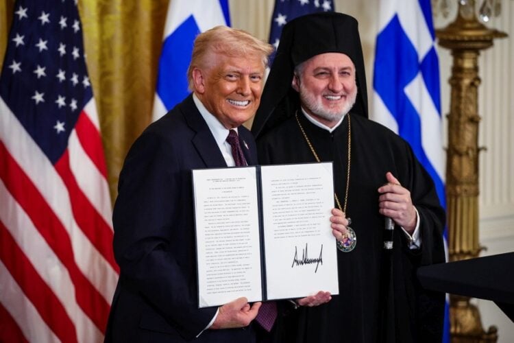 Ο πρόεδρος των ΗΠΑ κρατάει τη διακήρυξη που αναγνωρίζει την 25η Μαρτίου ως Ημέρα της Ελληνικής Ανεξαρτησίας. Δίπλα του ο Αρχιεπίσκοπος Αμερικής Ελπιδοφόρος (φωτ.: EPA/Samuel Corum/ POOL)