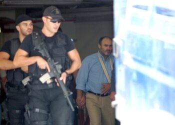 Ο Νίκος Παλαιοκώστας (Δ) συνοδεύεται από αστυνομικούς πίσω στην αστυνομική κλούβα για να μεταφερθεί από το Εφετείο στα δικαστήρια της οδού Ευελπίδων, την Παρασκευή 22 Σεπτεμβρίου 2006. (φωτ.: ΑΠΕ-ΜΠΕ/Παντελής Σαΐτας)