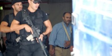 Ο Νίκος Παλαιοκώστας (Δ) συνοδεύεται από αστυνομικούς πίσω στην αστυνομική κλούβα για να μεταφερθεί από το Εφετείο στα δικαστήρια της οδού Ευελπίδων, την Παρασκευή 22 Σεπτεμβρίου 2006. (φωτ.: ΑΠΕ-ΜΠΕ/Παντελής Σαΐτας)