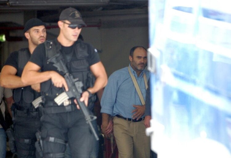 Ο Νίκος Παλαιοκώστας (Δ) συνοδεύεται από αστυνομικούς πίσω στην αστυνομική κλούβα για να μεταφερθεί από το Εφετείο στα δικαστήρια της οδού Ευελπίδων, την Παρασκευή 22 Σεπτεμβρίου 2006. (φωτ.: ΑΠΕ-ΜΠΕ/Παντελής Σαΐτας)