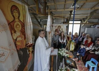 Ουκρανοί πιστοί παρακολουθούν την αναστάσιμη λειτουργία σε μια πρόχειρα κατασκευασμένη εκκλησία στο Κίεβο (φωτ.: EPA/Sergey Dolzhenko)