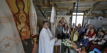 Ουκρανοί πιστοί παρακολουθούν την αναστάσιμη λειτουργία σε μια πρόχειρα κατασκευασμένη εκκλησία στο Κίεβο (φωτ.: EPA/Sergey Dolzhenko)