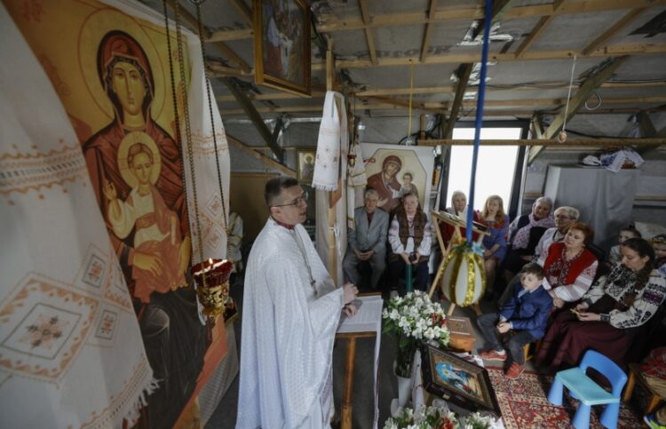 Ουκρανοί πιστοί παρακολουθούν την αναστάσιμη λειτουργία σε μια πρόχειρα κατασκευασμένη εκκλησία στο Κίεβο (φωτ.: EPA/Sergey Dolzhenko)