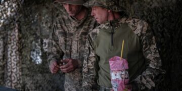 Ουκρανοί στρατιώτες κρατούν παραδοσιακά πασχαλινά γλυκά στη διάρκεια πρόχειρης λειτουργίας σε στρατιωτικό καταυλισμό (φωτ.: EPA/Maria Senovilla)