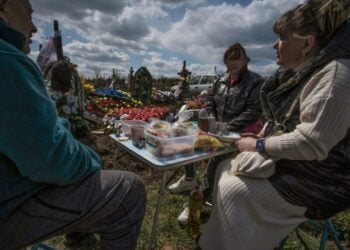 Οικογένεια Ουκρανών έχει στήσει ένα πρόχειρο τραπέζι με φαγητό δίπλα στον τάφο συγγενικού προσώπου, για το ταφικό έθιμο «Ημέρα Χαράς», ή «Προβόντι», παρόμοιο με αυτό των Ποντίων. Μία εβδομάδα μετά το Πάσχα, οι συγγενείς των νεκρών φέρνουν στο νεκροταφείο φαγητό, λουλούδια και προσωπικά αντικείμενα των νεκρών, προκειμένου να περάσουν την ημέρα μαζί (φωτ.: . EPA/Maria Senovilla)