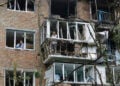 Κάτοικοι απομακρύνουν τα σπασμένα τζάμια από την 9ώροφη πολυκατοικία που έγινε στόχος drone στο Κίεβο (φωτ.: EPA / Sergey Dolzhenko)