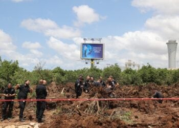 Αστυνομικοί εξετάζουν τον κρατήρα που άνοιξε ο πύραυλος όταν κατέπεσε δίπλα στο αεροδρόμιο Μπεν Γκουριόν (φωτ.: EPA/Abir Sultan)