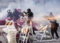 Αστυνομικοί ρίχνουν σε ακτιβιστές ενώ βρίσκονται κοντά σε αυτοσχέδιο οδόφραγμα κοντά στο ομοσπονδιακό δίκτυο Edward R. Roybal στο Λος Άντζελες (φωτ.: EPA/ CAROLINE BREHMAN)