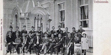 Επιστολικό δελτάριο με τη Φιλαρμονική της Τραπεζούντας. Στην πρώτη σειρά, πέμπτος από αριστερά, ο αρχιμουσικός Ανδρέας Ξύνδας (πηγή: Συλλογή Άννας Θεοφυλάκτου / Ιστορικό Αρχείο Προσφυγικού Ελληνισμού Δήμου Καλαμαριάς)