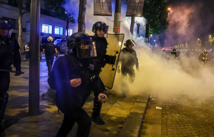 Αστυνομικοί κάνουν χρήση δακρυγόνων για να διαλύσουν τους οπαδούς της Παρί που είχαν συγκεντρωθεί στα Ηλύσια Πεδία (φωτ.: EPA / Christophe Petit Tesson)
