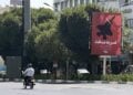 Ιρανός στην Τεχεράνη προσπερνά αφίσα η οποία αναγράφει «Σκληρή απάντηση» απεικονίζοντας ένα βομβαρδιστικό (φωτ.: EPA/Abedin Taherkenareh)