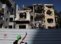 Ποδηλάτης βγάζει φωτογραφία μπροστά σε κατεστραμμένο κτήριο κατοικιών στο Τελ Αβίβ μετά από χτύπημα ιρανικού πυραύλου (φωτ.: . EPA/Abir Sultan)