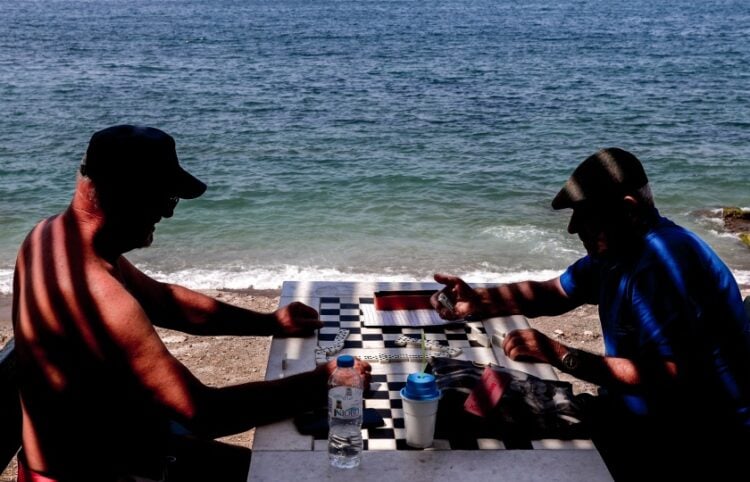 Ντόμινο πλάι στο κύμα για τους δύο κυρίους που απολαμβάνουν το καλοκαίρι τους (φωτ.: EUROKINISSI/Γιάννης Παναγόπουλος)