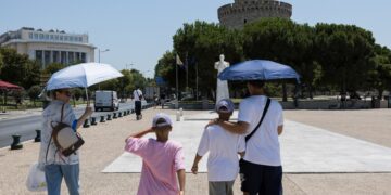 Τουρίστες κάνουν βόλτα στη Θεσσαλονίκη ενώ κρατούν ομπρέλες για να προστατευθούν από τον ήλιο, κατά τη διάρκεια ημέρας με πολύ υψηλές θερμοκρασίες (φωτ.: ΑΠΕ-ΜΠΕ/ΑΧΙΛΛΕΑΣ ΧΗΡΑΣ)