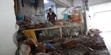 Η Σοφία Χατζηγεωργίου επιθεωρεί την τρύπα άνοιξε στη μεσοτοιχία του ημιώροφου διαμερίσματός της (φωτ.: EUROKINISSI / Ραφαήλ Γεωργιάδης)