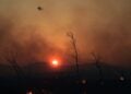Πυροσβεστικό ελικόπτερο επιχειρεί στιγμές πριν από τη δύση του ηλίου στη Δροσοπηγή (φωτ.: EUROKINISSI/Τατιάνα Μπόλαρη)