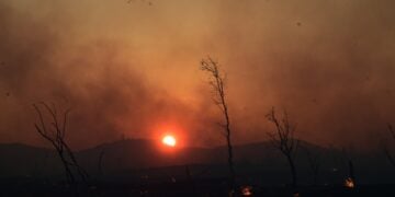 Πυροσβεστικό ελικόπτερο επιχειρεί στιγμές πριν από τη δύση του ηλίου στη Δροσοπηγή (φωτ.: EUROKINISSI/Τατιάνα Μπόλαρη)