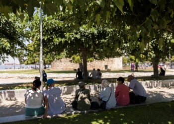 Τουρίστες κάθονται σε σκιερό μέρος στο κέντρο της Θεσσαλονίκης, ενώ επικρατούν υψηλές θερμοκρασίες (φωτ.: ΑΠΕ-ΜΠΕ / Αχιλλέας Χήρας)