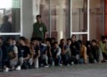 Πρόσφυγες και μετανάστες στέκονται έξω από το Λιμεναρχείο Λαυρίου (φωτ.: ΑΠΕ-ΜΠΕ / Γιάννης Κολεσίδης)