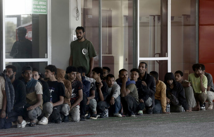 Πρόσφυγες και μετανάστες στέκονται έξω από το Λιμεναρχείο Λαυρίου (φωτ.: ΑΠΕ-ΜΠΕ / Γιάννης Κολεσίδης)