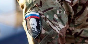 Στρατιώτης με διακριτικό που φέρει την εικόνα του Βλαντίμιρ Πούτιν και την ένδειξη «Assault Brigade Veterans» παρευρίσκεται σε εκδήλωση αποστολής βοήθειας προς τις εμπόλεμες ζώνες στην Ουκρανία (φωτ.: EPA / Sergei Ilnitsky)