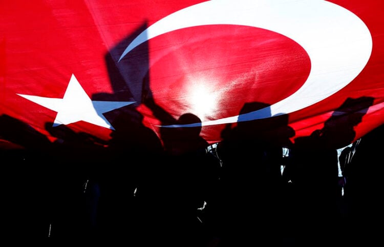 Τούρκοι διαδηλωτές κρατούν τη σημαία της χώρας τους (φωτ.: EPA / Sedat Suna)